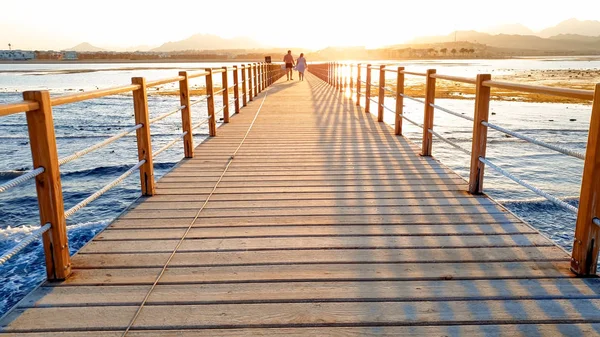 Όμορφη εικόνα της μακράς ξύλινη προβλήτα στο EA. καταπληκτικό ηλιοβασίλεμα πάνω από τη γέφυρα στον ωκεανό — Φωτογραφία Αρχείου