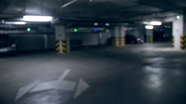 Immagine sfocata di parcheggio sotterraneo al piano terra di un edificio moderno. Perfetto sfondo grungy astratto — Foto Stock