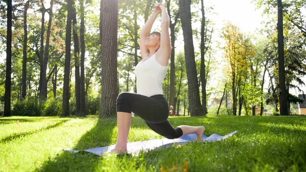 Photo d'une femme d'âge moyen pratiquant le yoga ou le fitness sur de l'herbe verte fraîche au parc. Santé physique et mentale des femmes. Personne dans la méditation et l'harmonie pf corps et âme — Photo