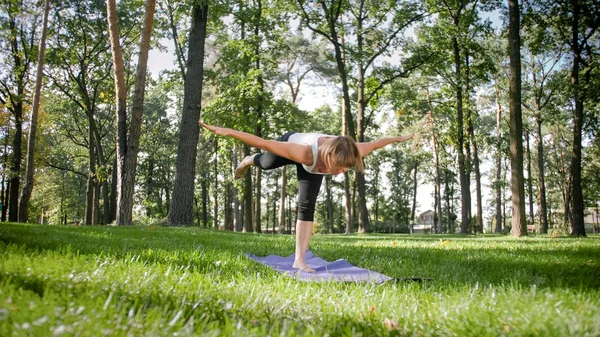 Zdjęcie w średnim wieku uśmiechnięta kobieta praktykujący jogę Asana. Persong medytowanie w przyrodzie. Równowaga i harmonia ciała i umysłu — Zdjęcie stockowe