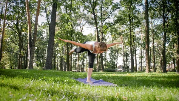 Zdjęcie uśmiechniętej kobiety robi jogi i ćwiczeń fitness. Ludzie w średnim wieku dbają o swoje zdrowie. Harmonia ciała i umysłu w przyrodzie — Zdjęcie stockowe