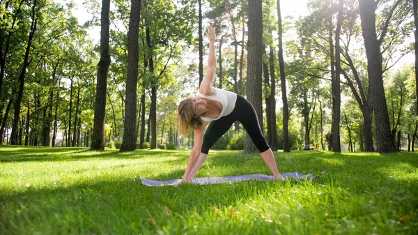 Zdjęcie w średnim wieku uśmiechnięta kobieta praktykujący jogę Asana. Persong medytowanie w przyrodzie. Równowaga i harmonia ciała i umysłu — Zdjęcie stockowe