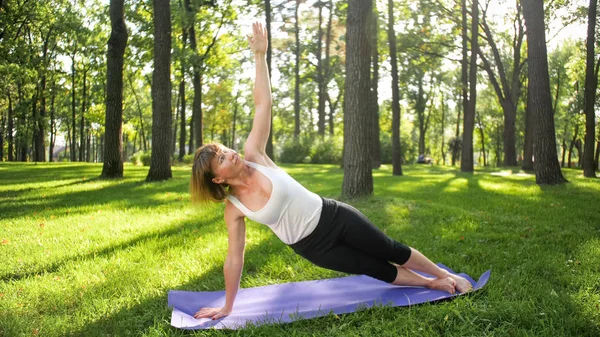 Foto di donna di mezza età che pratica yoga o fitness su erba verde fresca al parco. Salute fisica e mentale femminile. Persona in meditazione e armonia pf corpo e anima — Foto Stock