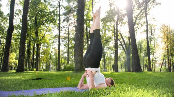 Foto de mulher sorridente de meia-idade praticando ioga asana. Persong meditando na natureza. Equilíbrio e harmonia de corpo e mente — Fotografia de Stock