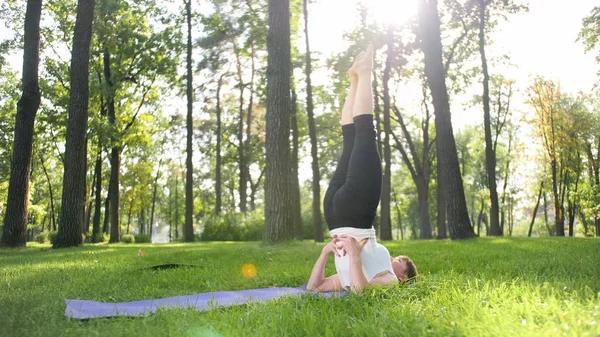 Zdjęcie kobiety w średnim wieku praktykujących jogę lub fitness na świeżym zielonym trawie w parku. Kobiece zdrowie fizyczne i psychiczne. Osoba w medytacji i harmonii PF ciała i duszy — Zdjęcie stockowe