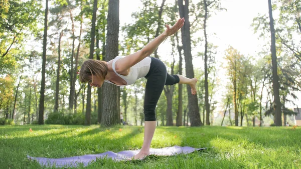 Zdjęcie kobiety w średnim wieku praktykujących jogę lub fitness na świeżym zielonym trawie w parku. Kobiece zdrowie fizyczne i psychiczne. Osoba w medytacji i harmonii PF ciała i duszy — Zdjęcie stockowe