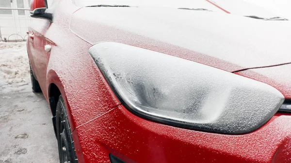 Nahaufnahme Foto von gefährlich eingefrorenen Scheinwerfern an rotem Auto — Stockfoto