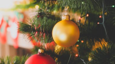 Dekore oturma odasında xmas ağacında asılı parlayan Noel ışığı ve güzel topları Tonlu closeup görüntü