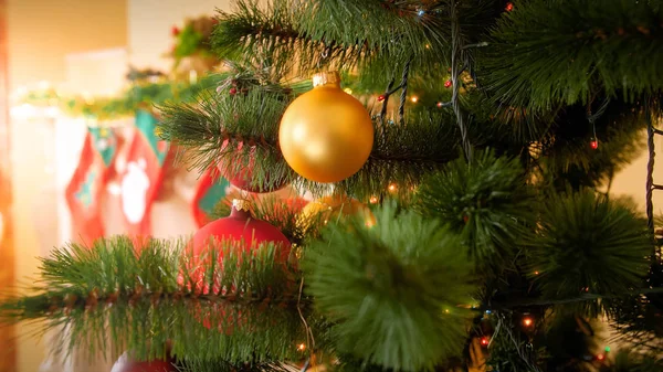 リビングルームに装飾されたクリスマスの木、贈り物のための靴下とモミの木の枝に金色のボーブルと美しい冬の休日の背景 — ストック写真