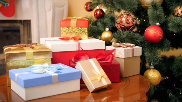 Vacker bild av massor av presenter och presenter till julen ligger på träbord på huset vardagsrum mot girlander och Chrismtas grannlåt — Stockfoto
