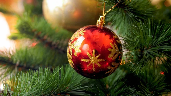 Foto de primer plano de la bola brillante roja en el hermoso árbol de Navidad. Fondo abstracto perfecto para vacaciones de invierno o celebraciones — Foto de Stock