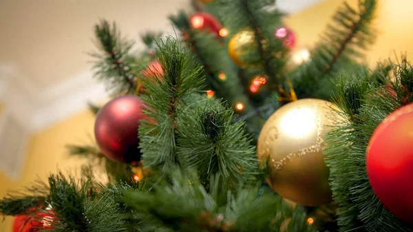 Vue former le sol sur le beau sapin de Noël décoré avec des lumières incandescentes et des boules scintillantes. Fond abstrait parfait pour les vacances d'hiver ou les célébrations — Photo