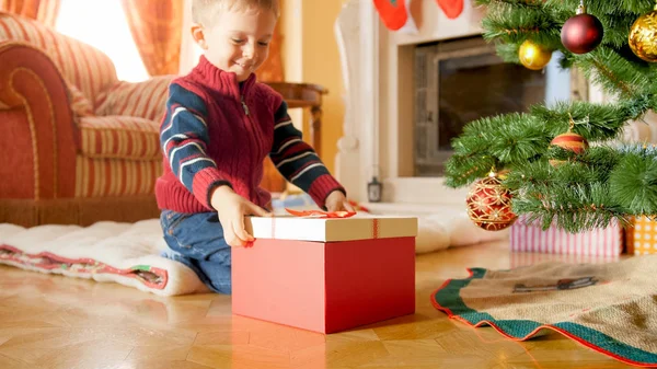 Retrato de niño sonriente alegre mirando la caja grande con regalo de Navidad — Foto de Stock