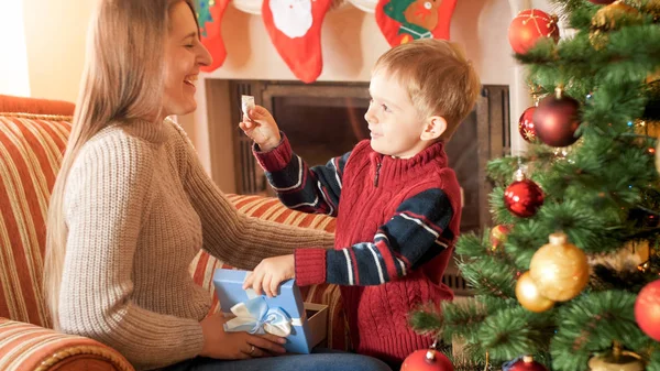 Şömine ve Noel ağacı ile oturma odasında Noel hediyeler ve hediyeler veren mutlu gülen aile Portresi — Stok fotoğraf