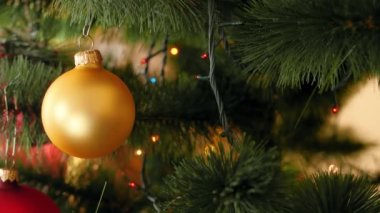 Güzel renkli topları ve yangın ağacı dalları üzerinde parlayan Noel ışıkları sürgü gelen 4k kaydırma video. Kış tatilleriniz ve kutlamalarınız için mükemmel çekim