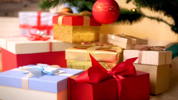 Βίντεο 4K της κάμερας αργά κινείται προς μεγάλο σωρό των Χριστουγέννων δώρα και δώρα σε διακοσμημένα κουτιά με κορδέλα φιόγκο στο πάτωμα στο σαλόνι. Τέλεια βολή για τις χειμερινές σας διακοπές και γιορτές — Αρχείο Βίντεο