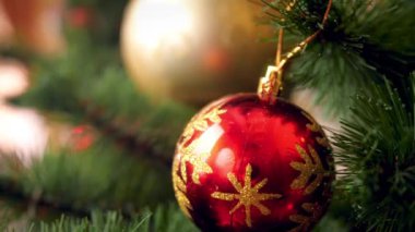 Renkli süsler, parlayan ışıklar ve Noel ağacı dalı üzerinde çelenk üzerinde hareket kamera Makro 4k kaydırma görüntüleri. Kış tatilleriniz ve kutlamalarınız için mükemmel çekim