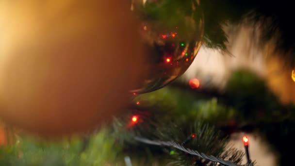 Vidéo 4k de caméra se déplaçant lentement entre l'arbre de Noël décoré de guirlandes colorées, de lumières et de boules. Plan parfait pour vos vacances et célébrations d'hiver 