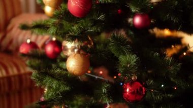 Kamera nın 4k video yavaş yavaş hareket eden ve oturma odasında Noel ağacı üzerinde renkli parlayan ışıklar ve süs eşyaları üzerinde kaydırma