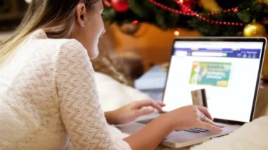 Noel için hediye ve hediye sipariş etmek için elinde kredi kartı ve alışveriş online tutan genç kadının Closeup 4k görüntüleri. Online alışveriş ve e-ticaret kavramı çekim.