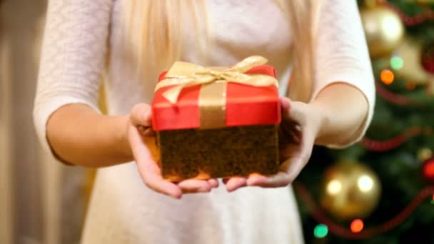 Closeup 4k footage of young woman holding red box with gifts and presents on Christmas from Santa Claus. Family giving and receiving presents on winter holidays and celebrations. — Stock Video