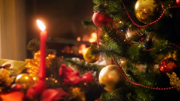 4k video de hermoso árbol de Navidad decorado con luces brillantes y fuego ardiente en firepalce. Perfecto para celebraciones de invierno y días festivos — Vídeo de stock
