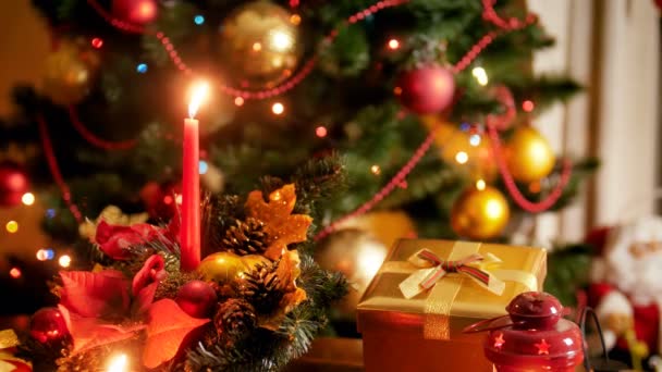 Imagens de close-up 4k de velas em chamas na grinalda de Natal contra a árvore de Natal decorada com luzes LED coloridas e brilhantes. Tiro perfeito para celebrações de inverno e feriados — Vídeo de Stock