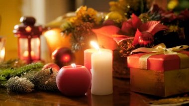 Noel çelenk ve Noel Baba hediyeleri ile süslenmiş masada yanan mumlar ve fenerler Closeup 4k görüntüleri. Kış kutlamaları ve tatiller için mükemmel çekim