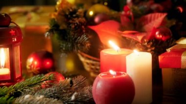 Mumlar, hediyeler ve hediyeler, fenerler, ahşap yemek masasına Noel çelenk yanan Closeup 4k panning video Yeni Yıl kutlamak için hizmet. Kış kutlamaları ve tatiller için mükemmel çekim