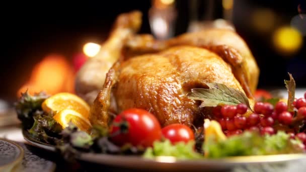 Closeup slow motion video of freshly baked turkey on Christmas dining table against burning fireplace and glowing lights on Christmas tree — Stock Video