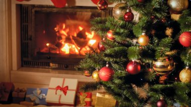 Noel hediyelerinin ve yanan şöminenin ve Noel ağacının yanındaki hediyelerin yakın çekimi.
