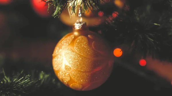 Closeup toned retro photo of golden shiny bauble hanging on Christmas tree — ストック写真