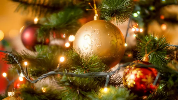 Closeup photo of lots of red and golden baubles hanging on decorated Christmas tree in living room — Stock Photo, Image