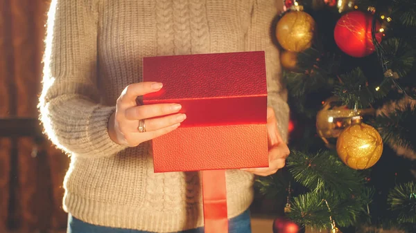 Closeup tonificado imagem da mulher em suéter abre caixa com presente de Natal — Fotografia de Stock