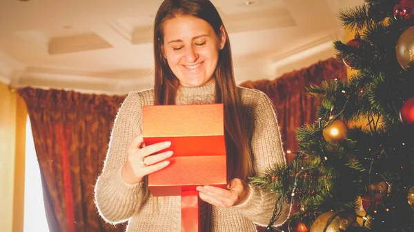 Mutlu gülümseyen kadının tonlarca portresi Noel hediyesi kutusuna bakıyor. — Stok fotoğraf