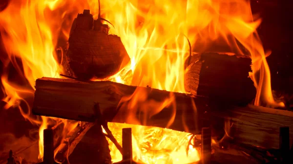 Closeup image of fire flames on burning wooden logs in fireplace — Stock Photo, Image