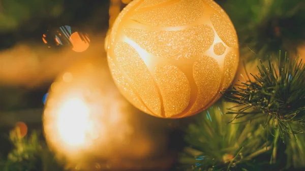 Closeup toned image of two golden balls with glitters hanging on Christmas tree — ストック写真