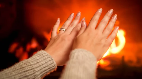 Nahaufnahme von weiblichen Händen, die sich am Kamin wärmen. Wohlfühlen am heimischen Feuer — Stockfoto