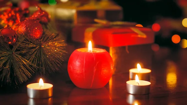 Foto de primer plano de la vela roja ardiendo en la mesa de madera decorada para Navidad — Foto de Stock