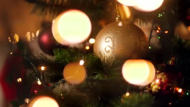 Closeup vídeo de luzes brilhantes borradas brilhando sobre a árvore de Natal com bugigangas — Vídeo de Stock