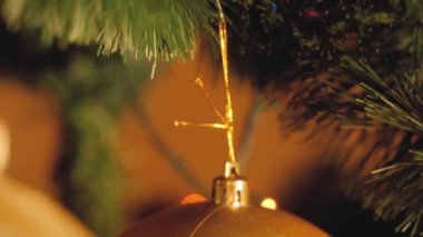 Evdeki güzel Noel ağacında asılı renkli mücevherlerin yakın çekim videosu.