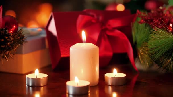 Primer plano 4k video de la quema de velas de adviento contra regalos de Navidad y regalos en la sala de estar con la quema de firepalce. Fondo o telón de fondo perfecto para Navidad o Año Nuevo — Vídeos de Stock