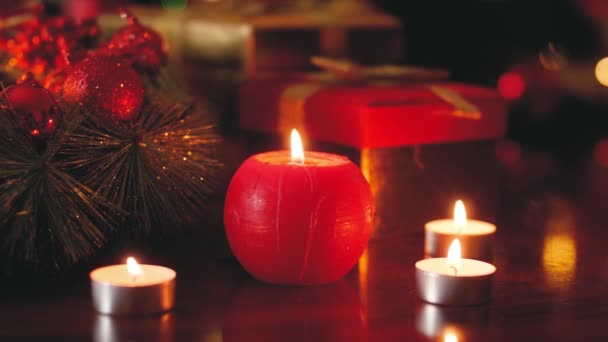 Detailně tónované 4K záběry hořící svíčky na dřevěném stole zdobeném na Štědrý den. Perfektní pozadí nebo pozadí pro Vánoce nebo Nový rok — Stock video
