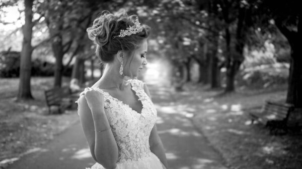 Black and white portrait of beautiful sexy bride on long aley at park.