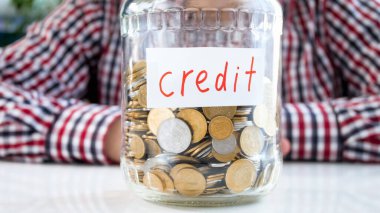 Üzerinde Credit yazan bozuk para dolu cam kavanoz. Finans, ekonomik büyüme ve banka tasarrufu kavramı