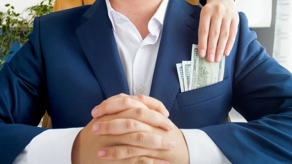 Imagem close-up de pessoa colocando dinheiro suborno no bolso politican corrompido. Conceito de corrupção na política e no governo — Fotografia de Stock