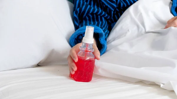 Closeup photo of young sick woman holding thoat spray in hand — Stock Photo, Image