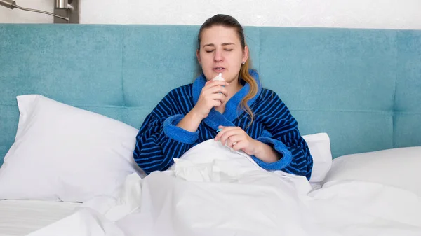 Mujer joven enferma con secreción nasal usando aerosol nasal — Foto de Stock