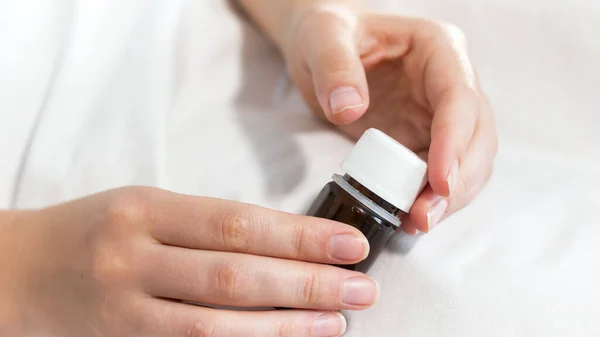 Imagen de primer plano de una paciente mujer sosteniendo el frasco con medicamentos y pastillas en la mano — Foto de Stock