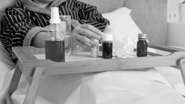 Noir Adn portrait blanc de la femme malade prenant des médicaments fom plateau en bois dans le lit — Photo